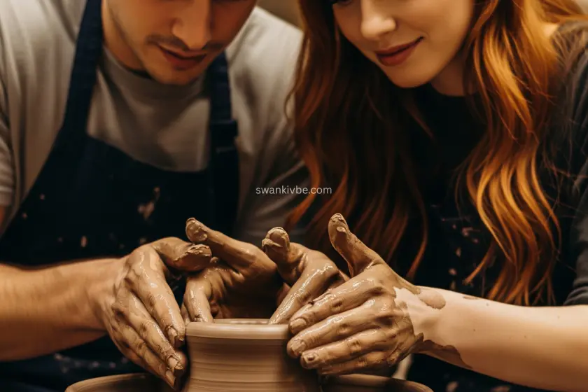 A couple at a pottery wheel, hands covered in clay, shaping a bowl together.