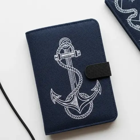  A navy organic canvas passport cover with white anchor and rope embroidery.
