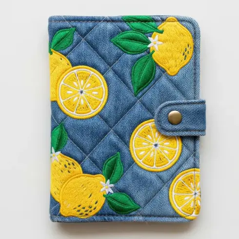  A recycled denim quilted passport cover with bright lemon embroidery in yellow and green.