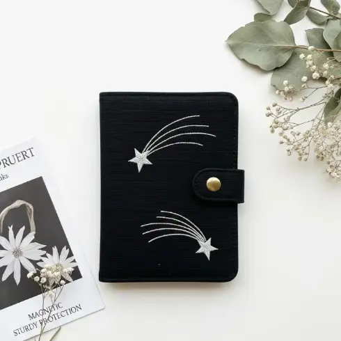  black organic cotton passport cover with silver shooting star embroidery.