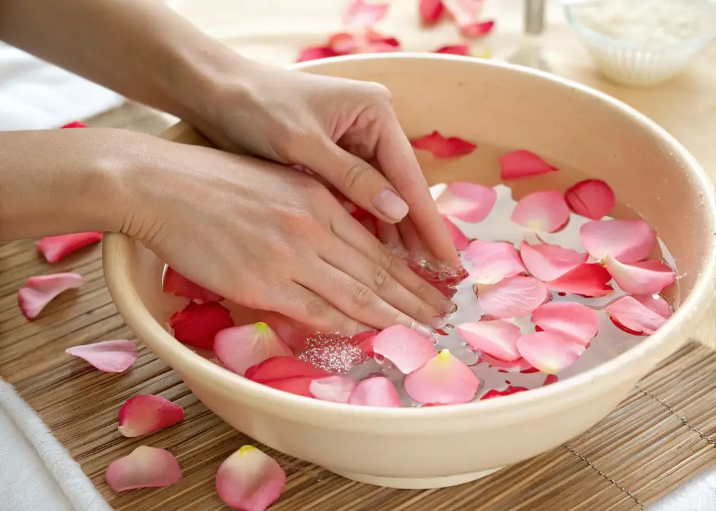  Hands enjoying a relaxing soak with petals.